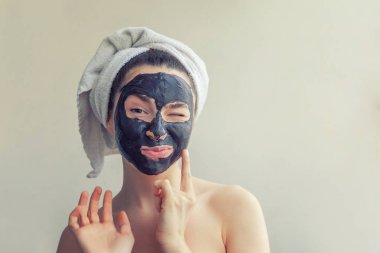 Kadının yüzündeki siyah besleyici maske uygulamak