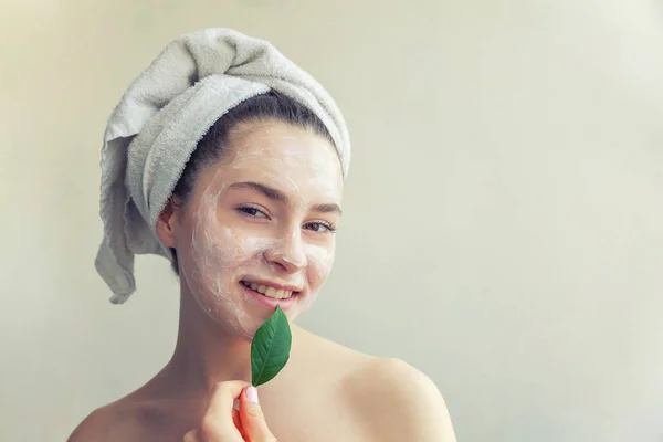 Kadın yüzü ile yaprak yeşil ve krem ya da besleyici maske — Stok fotoğraf