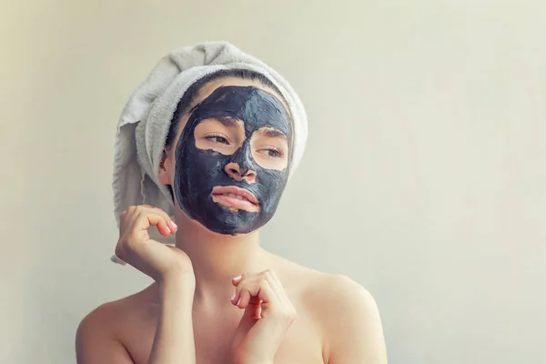 女性の顔に黒い栄養マスクを適用します。 — ストック写真