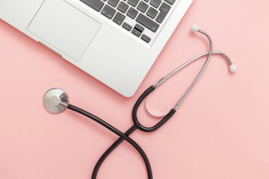 Pembe arka plan üzerinde izole Stetoskop klavye dizüstü bilgisayar. Modern tıbbi Bilgi teknolojisi ve sofware gelişmeler kavramı. Bilgisayar ve gadget tanılama ve onarım