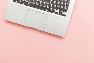 Pembe pastel masa arka planda izole klavye dizüstü bilgisayar. Modern bilgi teknolojisi ve yazılım gelişmeleri