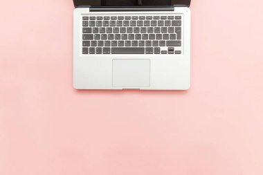 Pembe pastel masa arka planda izole klavye dizüstü bilgisayar. Modern bilgi teknolojisi ve yazılım gelişmeleri
