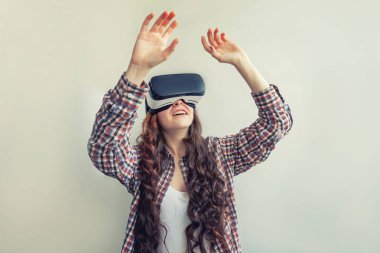 Beyaz arka planda sanal gerçeklik Vr gözlük kask kulaklık kullanarak giyen smile genç kadın. Sanal gerçeklik gözlüğü ile akıllı telefon kullanımı