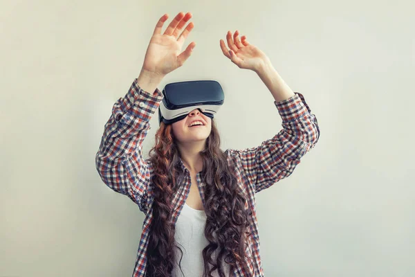Sonríe mujer joven usando realidad virtual gafas VR casco auriculares sobre fondo blanco. Smartphone con gafas de realidad virtual — Foto de Stock