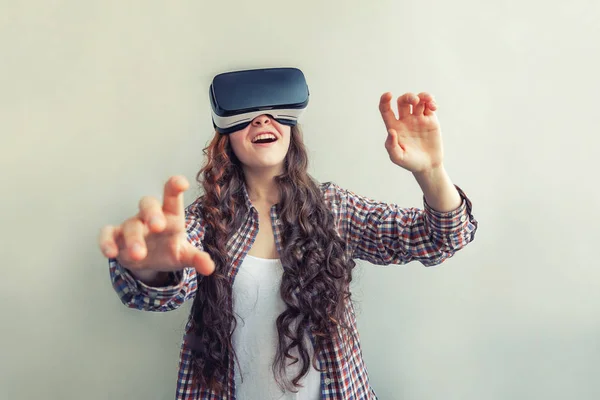 Sonríe mujer joven usando realidad virtual gafas VR casco auriculares sobre fondo blanco. Smartphone con gafas de realidad virtual — Foto de Stock