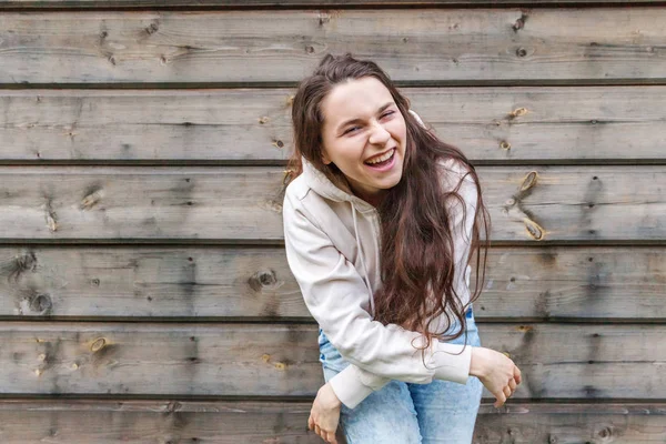 Menina feliz sorrindo. Beleza retrato jovem feliz positivo rindo morena mulher no fundo da parede de madeira — Fotografia de Stock