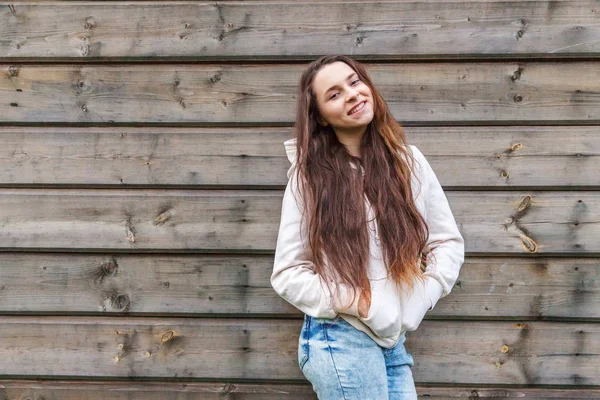 Mutlu kız gülümsüyor. Ahşap duvar arka plan üzerinde Güzellik portre genç mutlu pozitif gülen esmer kadın