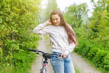 Yaz şehir parkı açık havada bisiklete binen genç kadın. Aktif insanlar. Hipster kız dinlenmek ve binici bisiklet