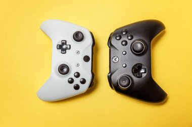 Sarı arka planda beyaz ve siyah iki joystick. Bilgisayar oyun Yarışması videogame kontrol çatışma kavramı