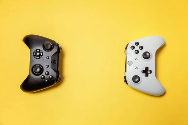 Bianco e nero due joystick su sfondo giallo. Concorso di gioco per computer concetto di confronto di controllo videogame — Foto Stock