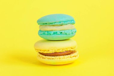 Fransız tatlı kurabiye. Çok az yiyecek ekmek kavramı. Sarı zemin üzerine mavi ve sarı macaron