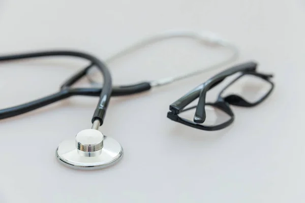 Equipo de medicina estetoscopio o fonendoscopio y gafas aisladas sobre fondo blanco. Instrumento para médico. Concepto de seguro de vida de salud — Foto de Stock