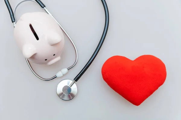 Medicina equipamento médico estetoscópio ou fonendoscópio porquinho e coração vermelho isolado em fundo branco — Fotografia de Stock