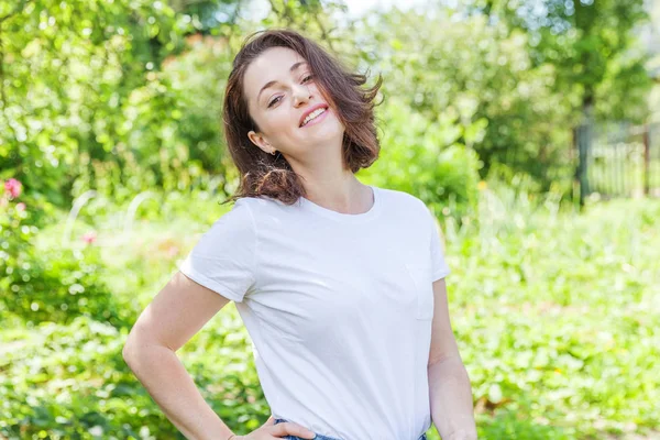 Menina feliz sorrindo. Retrato de beleza jovem feliz positivo rindo morena mulher no parque ou jardim fundo — Fotografia de Stock