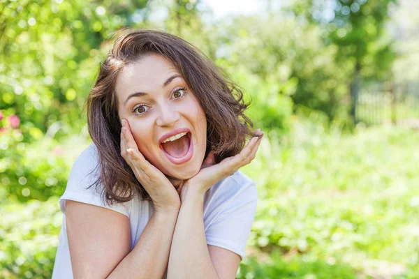 Menina feliz sorrindo. Retrato de beleza jovem feliz positivo rindo morena mulher no parque ou jardim fundo — Fotografia de Stock