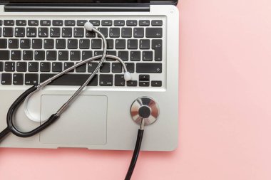 Pembe arka plan üzerinde izole Stetoskop klavye dizüstü bilgisayar. Modern tıbbi Bilgi teknolojisi ve sofware gelişmeler kavramı. Bilgisayar ve gadget tanılama ve onarım
