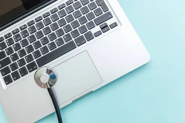 Stethoscope keyboard laptop computer isolated on blue background. Modern medical Information technology and sofware advances concept. Computer and gadget diagnostics and repair