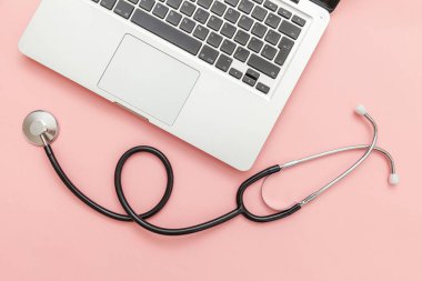 Pembe arka plan üzerinde izole Stetoskop klavye dizüstü bilgisayar. Modern tıbbi Bilgi teknolojisi ve sofware gelişmeler kavramı. Bilgisayar ve gadget tanılama ve onarım