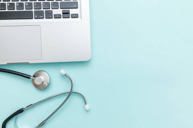 Stetoskop klavye dizüstü bilgisayarı mavi arkaplanda izole edilmiş. Modern tıbbi bilgi teknolojisi ve yazılımlar konsepti geliştirir. Bilgisayar ve aygıt tanılama ve onarım