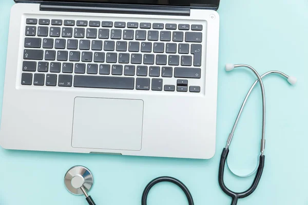 Stethoscope keyboard laptop computer isolated on blue background. Modern medical Information technology and sofware advances concept. Computer and gadget diagnostics and repair