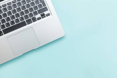 Mavi Pastel masa arka planda izole klavye dizüstü bilgisayar. Modern bilgi teknolojisi ve yazılım gelişmeleri
