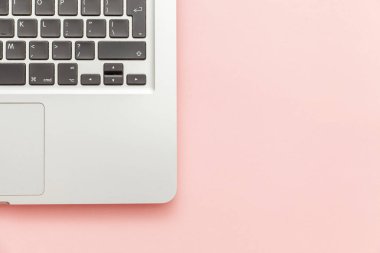 Pembe pastel masa arka planda izole klavye dizüstü bilgisayar. Modern bilgi teknolojisi ve yazılım gelişmeleri