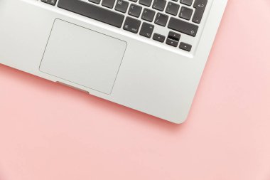 Pembe pastel masa arka planda izole klavye dizüstü bilgisayar. Modern bilgi teknolojisi ve yazılım gelişmeleri