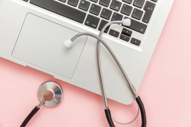 Pembe arka plan üzerinde izole Stetoskop klavye dizüstü bilgisayar. Modern tıbbi Bilgi teknolojisi ve sofware gelişmeler kavramı. Bilgisayar ve gadget tanılama ve onarım
