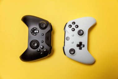 Sarı arka planda beyaz ve siyah iki joystick. Bilgisayar oyun Yarışması videogame kontrol çatışma kavramı