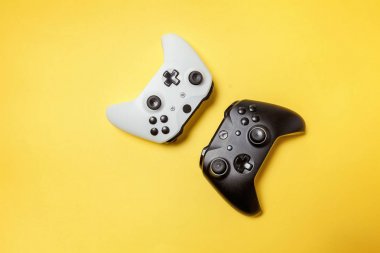 Sarı arka planda beyaz ve siyah iki joystick. Bilgisayar oyun Yarışması videogame kontrol çatışma kavramı