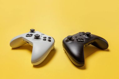 Sarı arka planda beyaz ve siyah iki joystick. Bilgisayar oyun Yarışması videogame kontrol çatışma kavramı