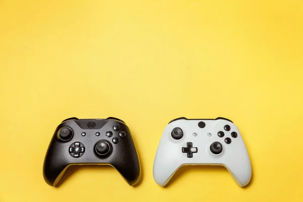 Biały i czarny dwa joysticki na żółtym tle. Konkurs gier komputerowych gry kontroli konfrontacji koncepcja — Zdjęcie stockowe
