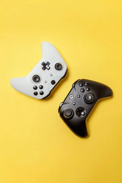 흰색 및 검은색 노란색 배경에 두 개의 조이스틱. 컴퓨터 게임 경쟁 비디오 게임 제어 대결 개념 — 스톡 사진