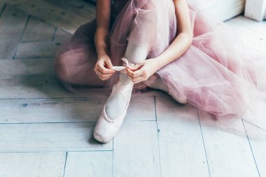 Balerin eller dans dersi bacağından pointe ayakkabı koyar