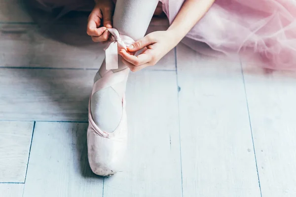 Bailarina manos pone zapatos puntiagudos en la pierna en clase de baile —  Fotos de Stock