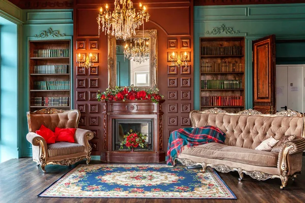 Ev kütüphanesinin lüks klasik iç. Kitaplık, kitap, kol koltuğu, kanepe ve şömineile oturma odası — Stok fotoğraf