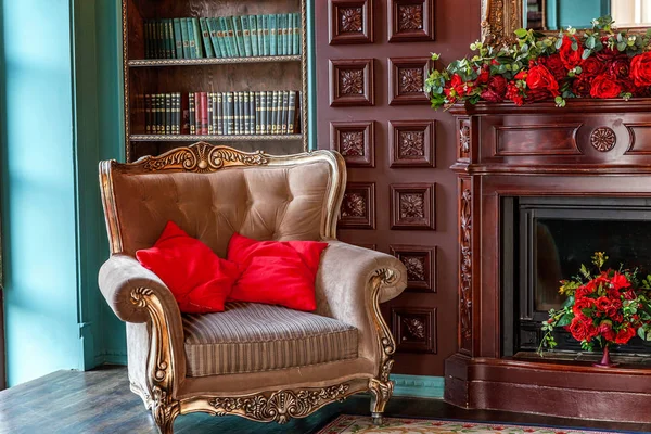 Luxury classic interior of home library. Sitting room with bookshelf, books, arm chair, sofa and fireplace