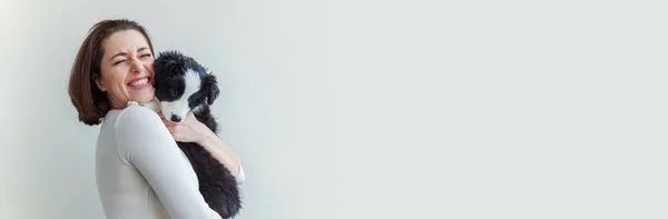 Sonriendo joven atractiva mujer abrazando abrazo lindo perrito frontera collie aislado en banner de fondo blanco — Foto de Stock