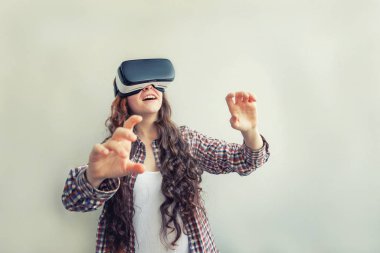 Beyaz arka planda sanal gerçeklik Vr gözlük kask kulaklık kullanarak giyen smile genç kadın. Sanal gerçeklik gözlüğü ile akıllı telefon kullanımı