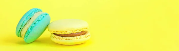 Biscoito doce francês. Conceito mínimo de padaria de alimentos. Macaron azul e amarelo no fundo amarelo — Fotografia de Stock