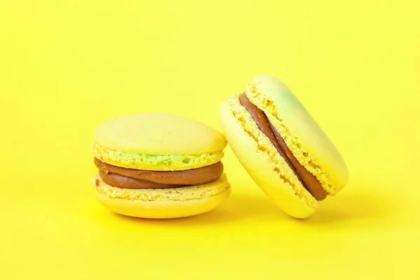 French sweet cookie. Minimal food bakery concept. Yellow macaron cake isolated on yellow background