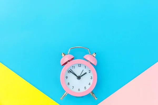 Reloj despertador vintage aislado sobre fondo geométrico azul amarillo pastel colorido de moda —  Fotos de Stock