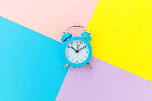 Reloj despertador vintage aislado sobre fondo geométrico azul amarillo pastel colorido de moda —  Fotos de Stock