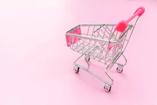 Små stormarknad livsmedelsbutik leksak push vagn isolerad på rosa pastell färgglada bakgrund — Stockfoto