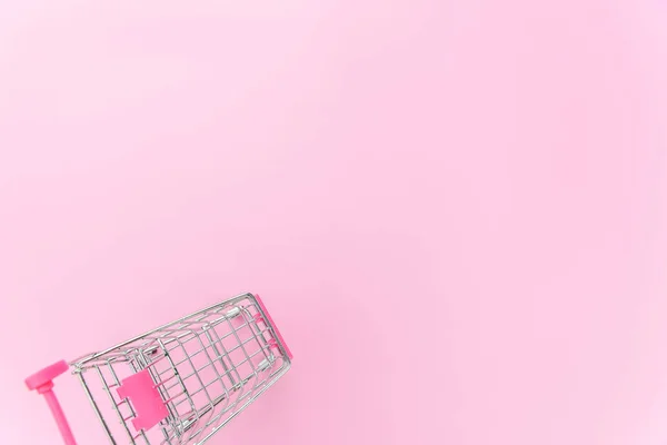Pequeño supermercado supermercado juguete empuje carro aislado en rosa pastel colorido fondo — Foto de Stock