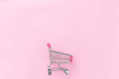 Pembe pastel renkli arka planda izole küçük süpermarket bakkal oyuncak Push cart
