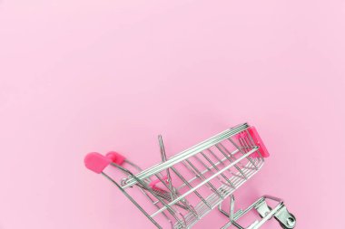 Pembe pastel renkli arka planda izole küçük süpermarket bakkal oyuncak Push cart