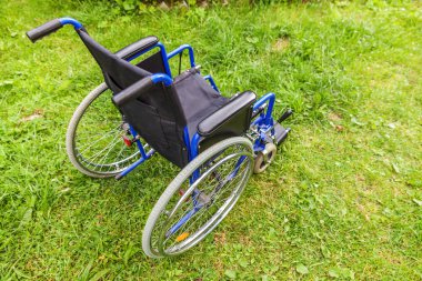 Hasta Hizmetleri için bekleyen hastane parkında çim boş tekerlekli sandalye ayakta