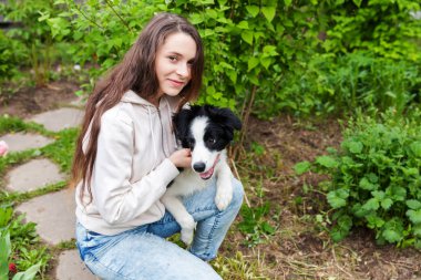 Gülümseyen genç çekici kadın yaz şehir parkı açık arka planda sevimli köpek yavrusu sınır collie sarılma kucaklayan