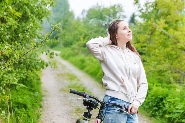 Jovem mulher andando de bicicleta no parque da cidade de verão ao ar livre. Pessoas activas. Hipster menina relaxar e andar de bicicleta — Fotografia de Stock